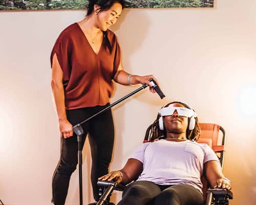Dr. Lynn giving a woman a cold laser therapy treatment