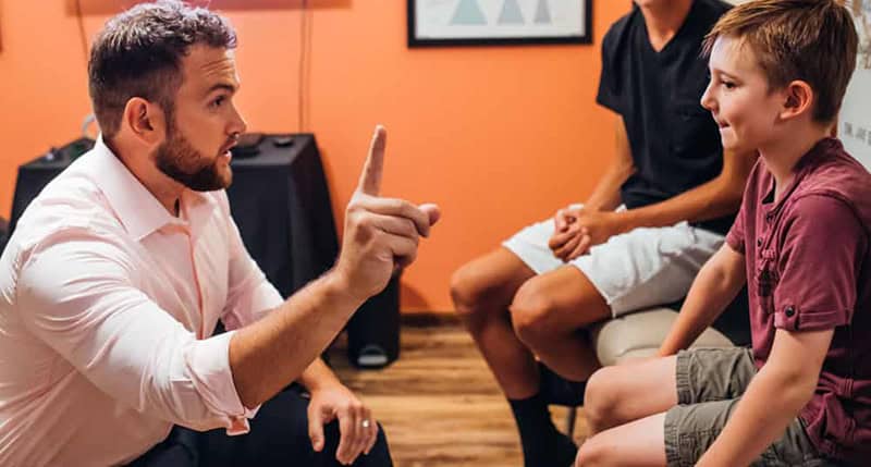 Dr. Sam with a child sitting on bench talking